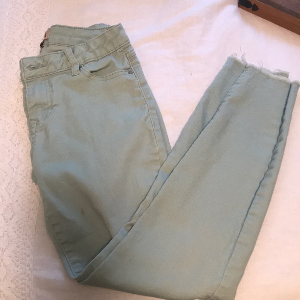 Mint skinny jeans with distressed bottoms